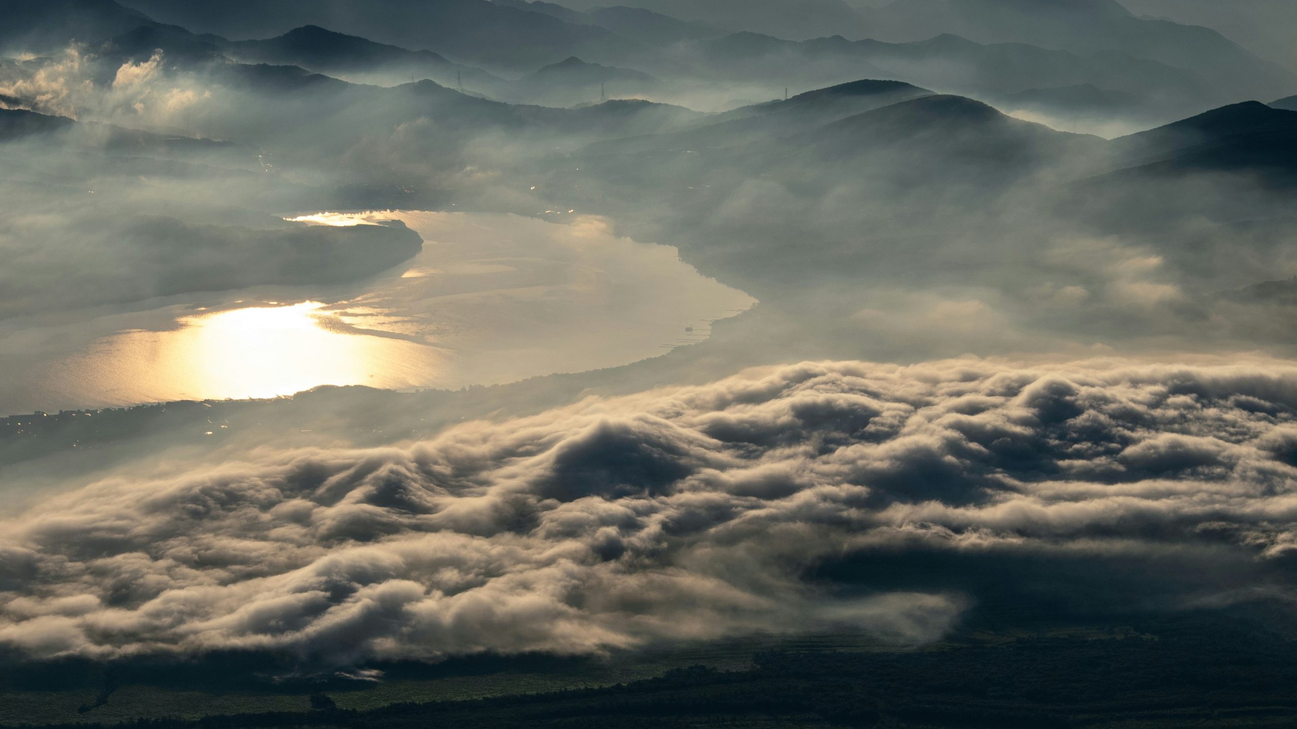 Peaceful landscape photography of a lush green vineyard with mountains in the background under a partly cloudy sky