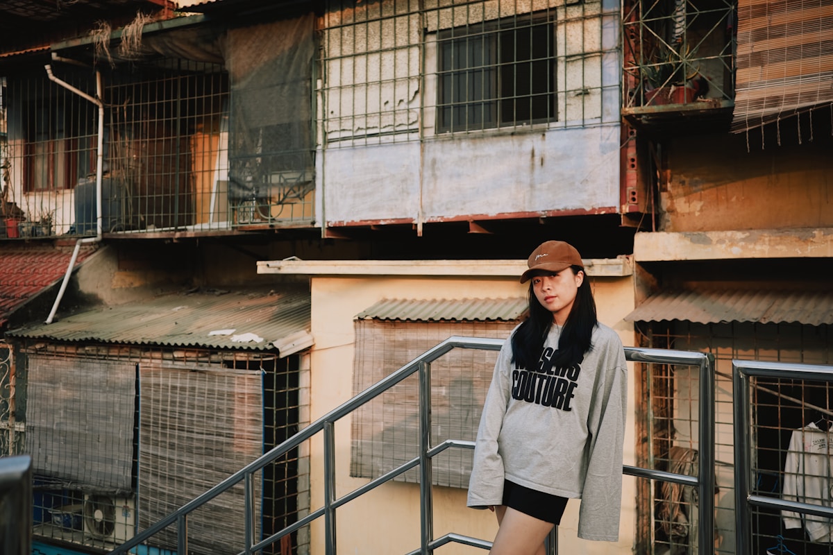 Young woman in casual clothes stands on outdoor stairs.