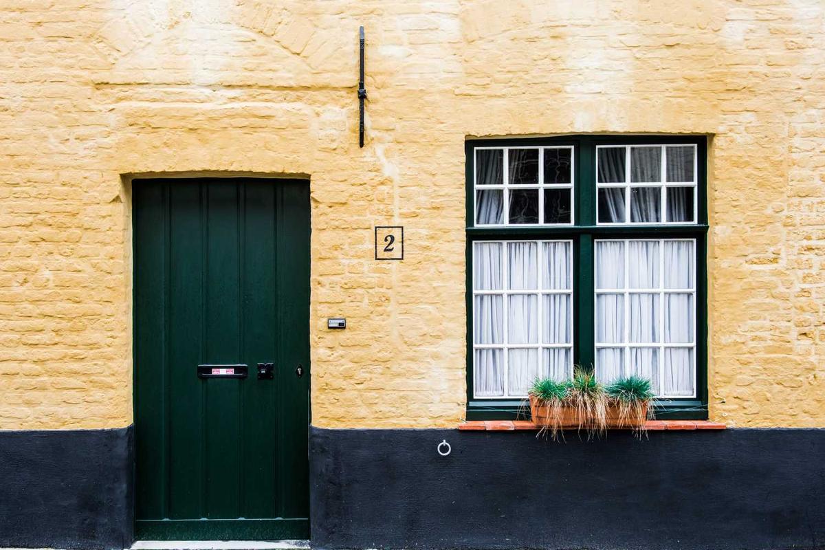 Brick building with door, window, and number two.