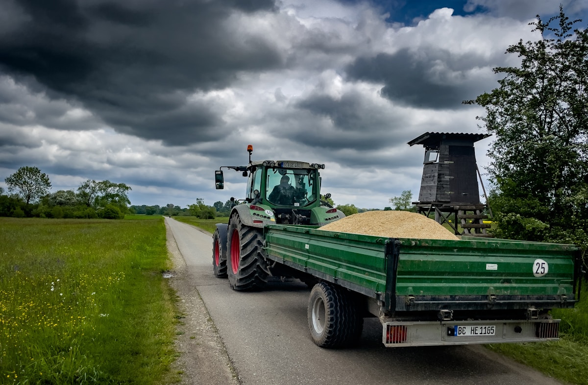a tractor pulling a trailer down a country road