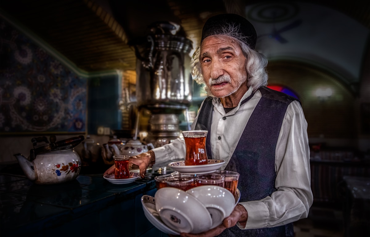 Elderly man serving tea from a samovar
