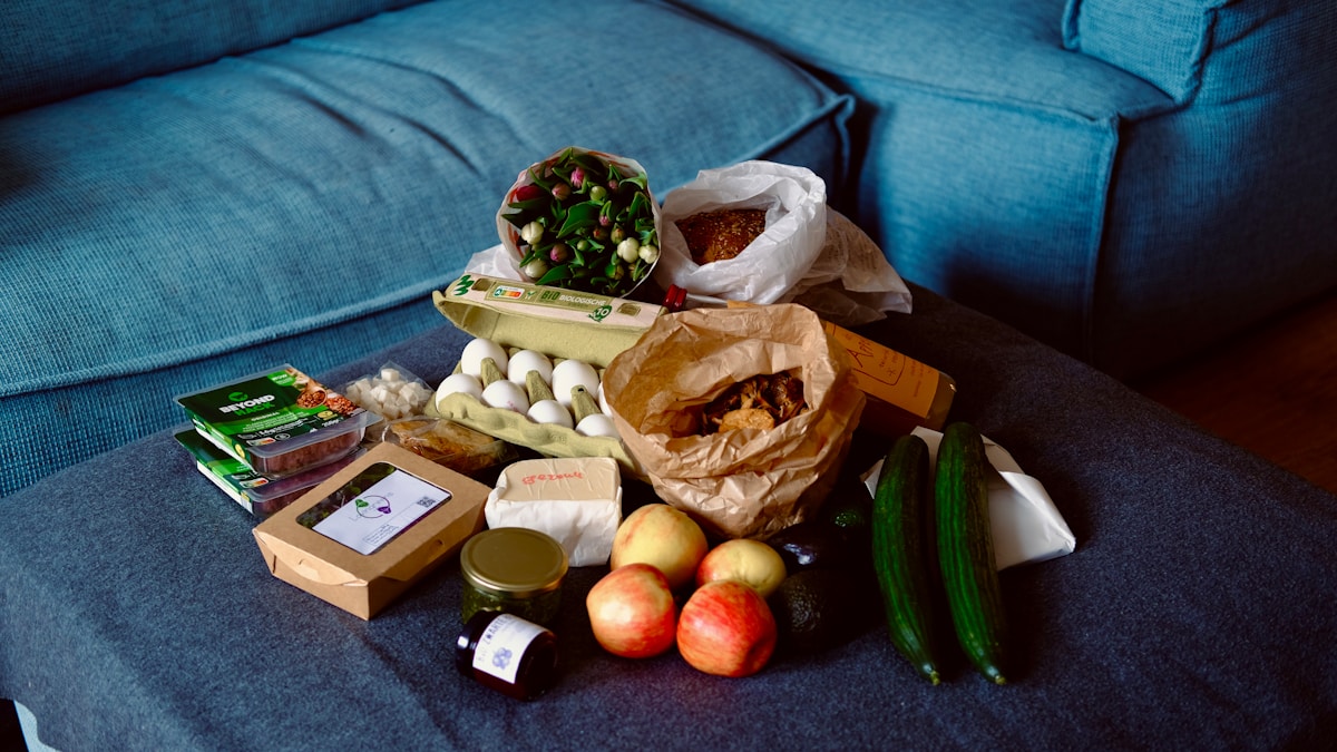 Groceries are arranged on a blue sofa.