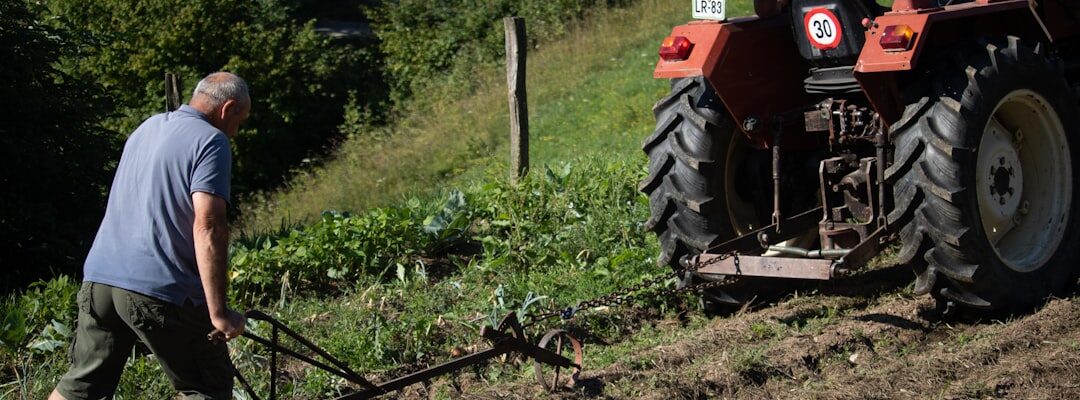 "Un agriculteur utilise un tracteur pour optimiser son désherbage mécanique en bio sur une pente herbeuse en labourant le cha