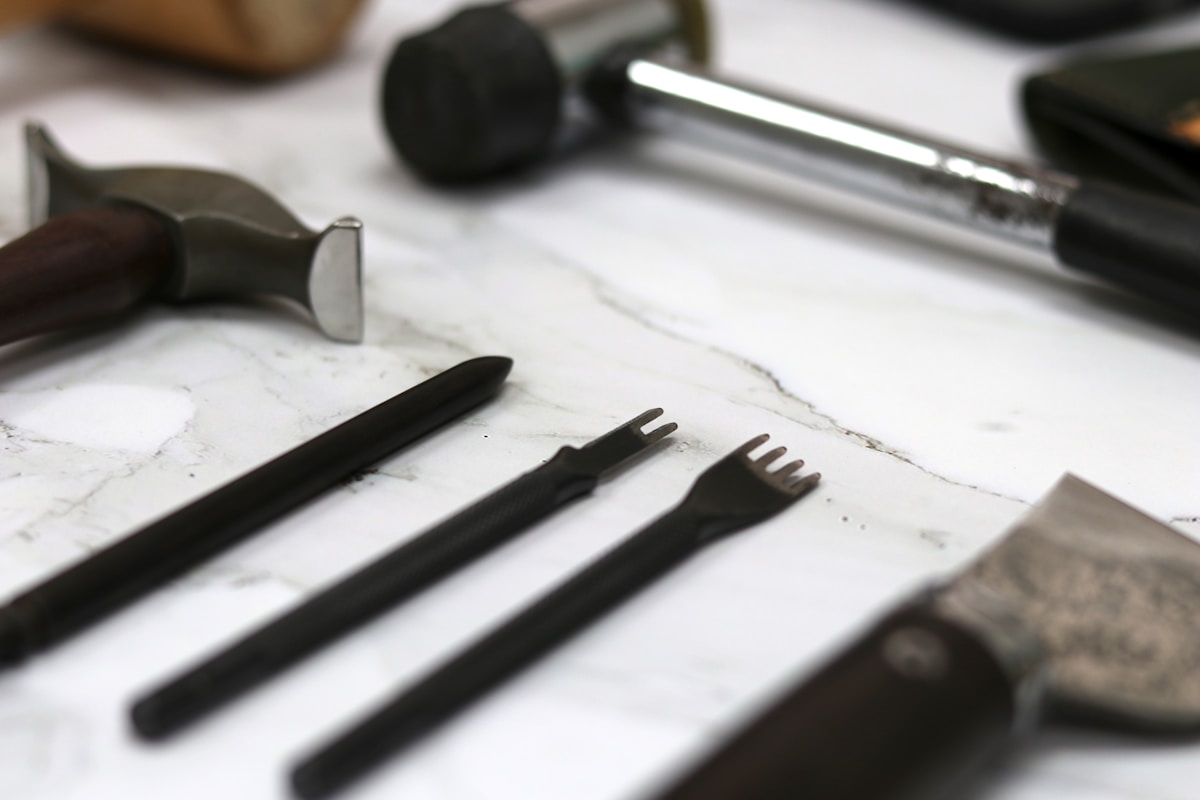 Un agriculteur professionnel utilise un désherbeur thermique dans un vignoble, la flamme est visible sur la végétation au sol, un paysage agricole ensoleillé avec des rangées de cultures en arrière-plan