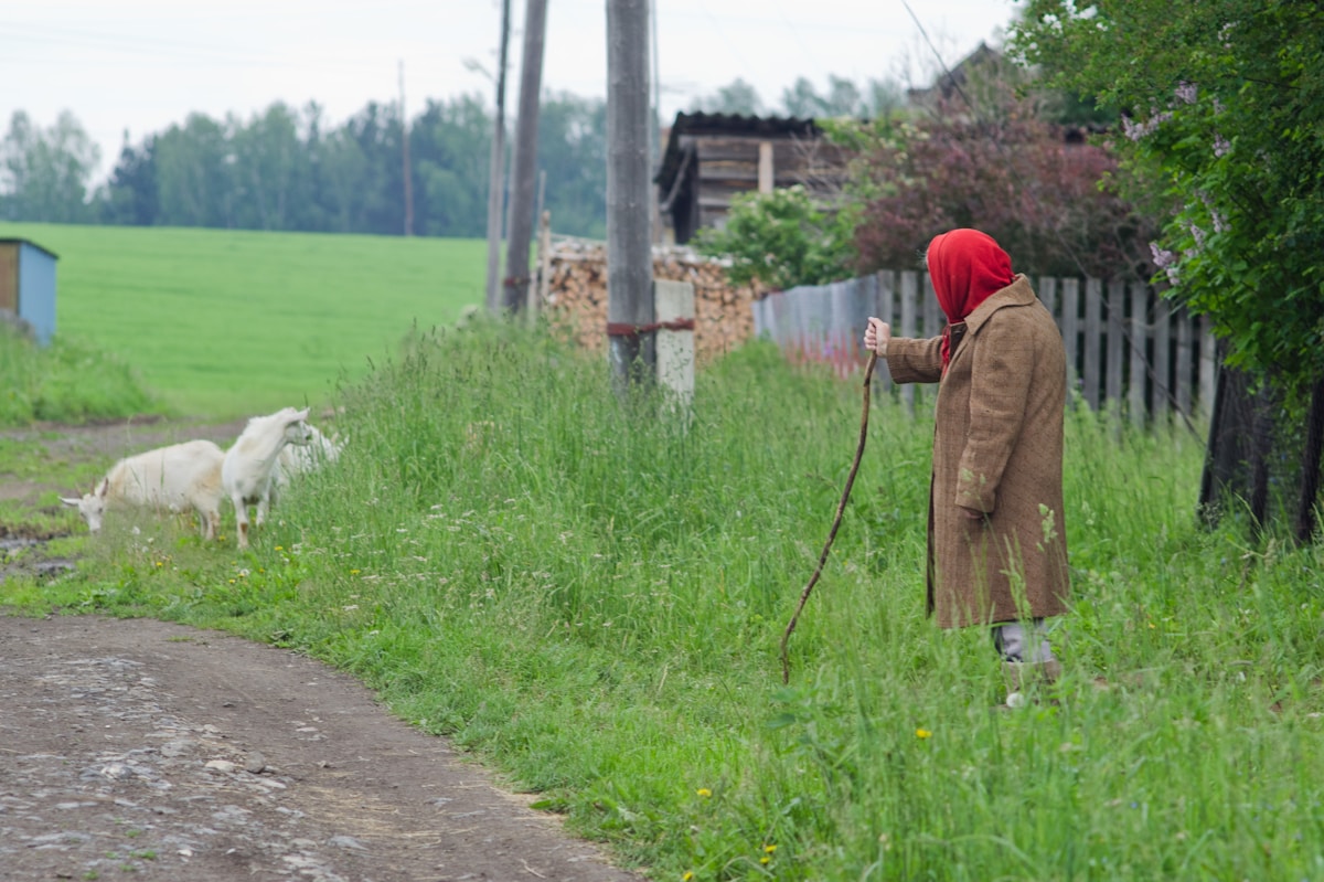 Un homme en manteau brun marchant sur un sentier.