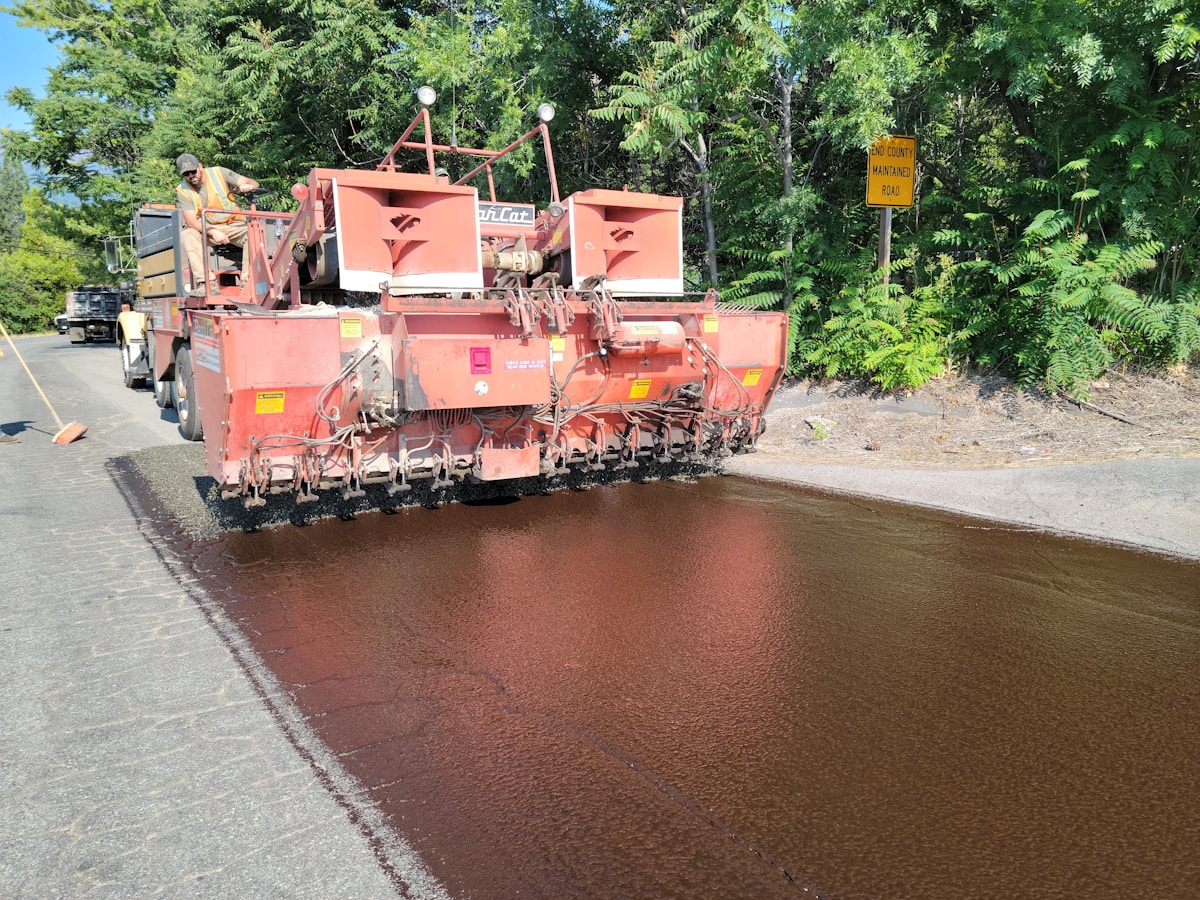Asphalt paving machine laying fresh asphalt on road