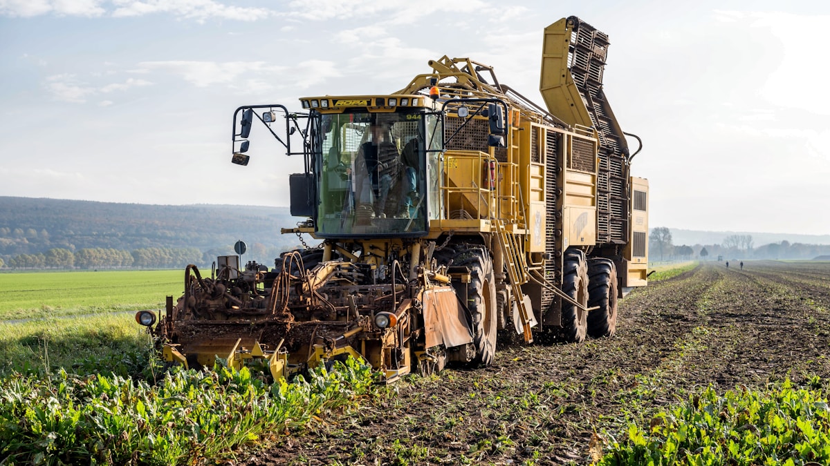 Tracteur agricole puissant travaillant dans un champ verdoyant.