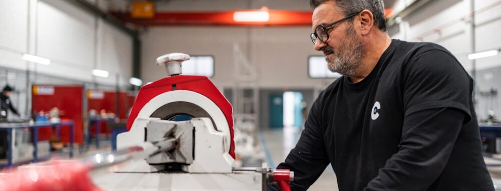 Un homme reçoit un conseil technique tout en utilisant une machine industrielle dans un atelier.