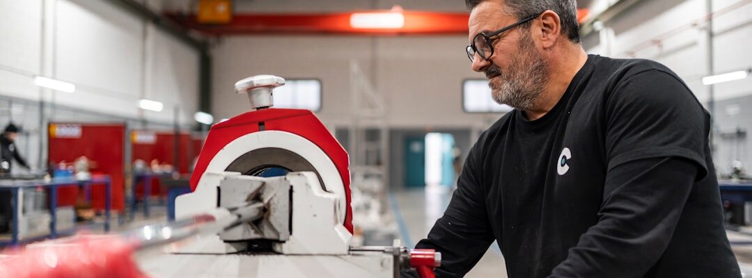 Un homme reçoit un conseil technique tout en utilisant une machine industrielle dans un atelier.