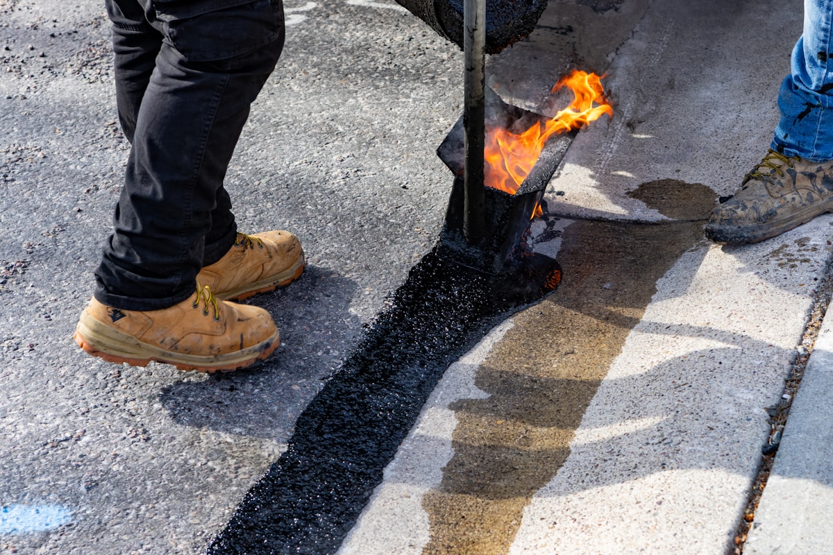 Travaux de réparation de la chaussée avec flamme brûlante.