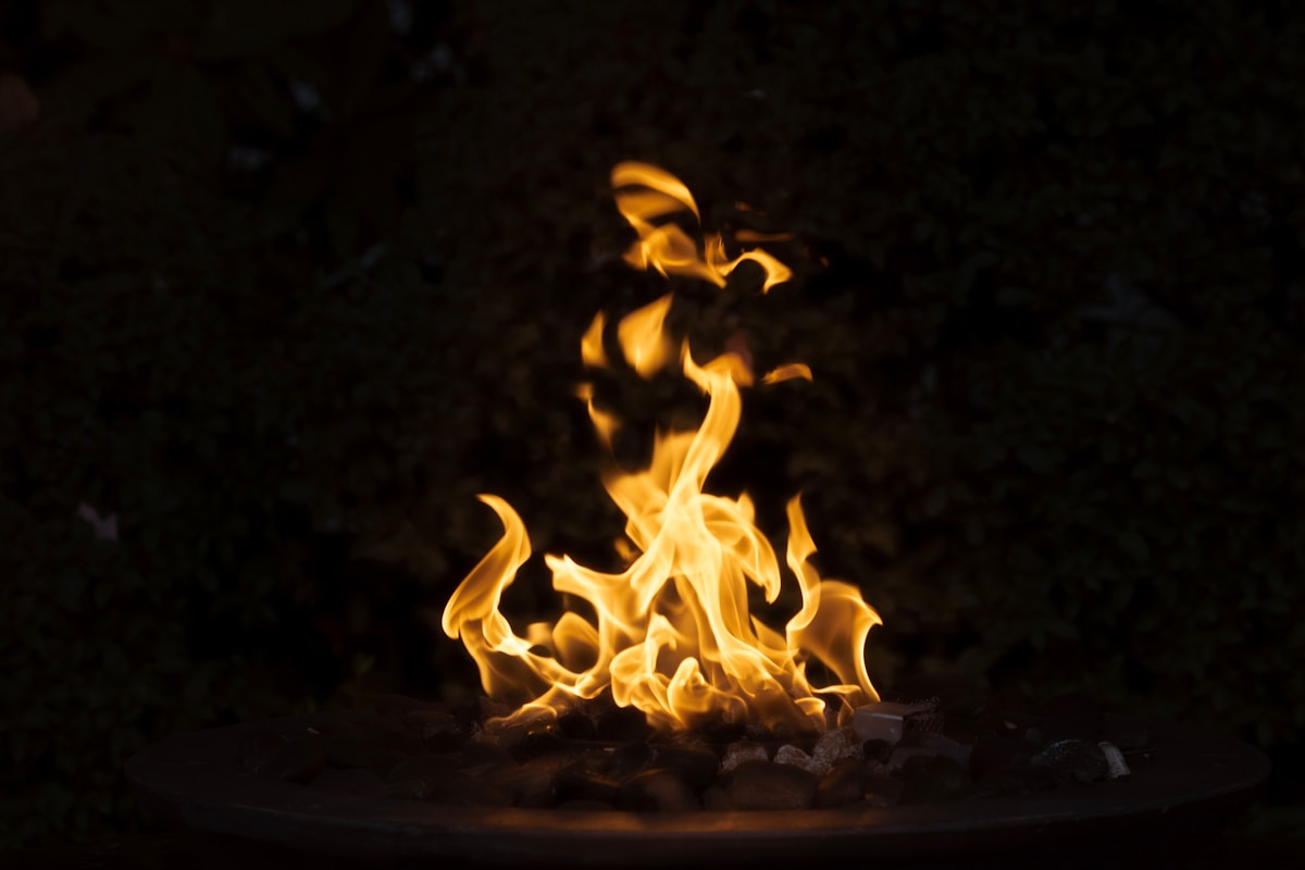Flammes oranges et jaunes d'un feu de camp brûlant dans l'obscurité.