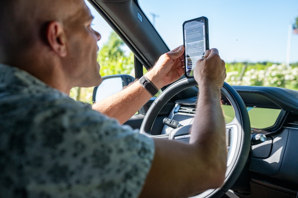 Homme utilisant un téléphone portable tout en conduisant un véhicule.