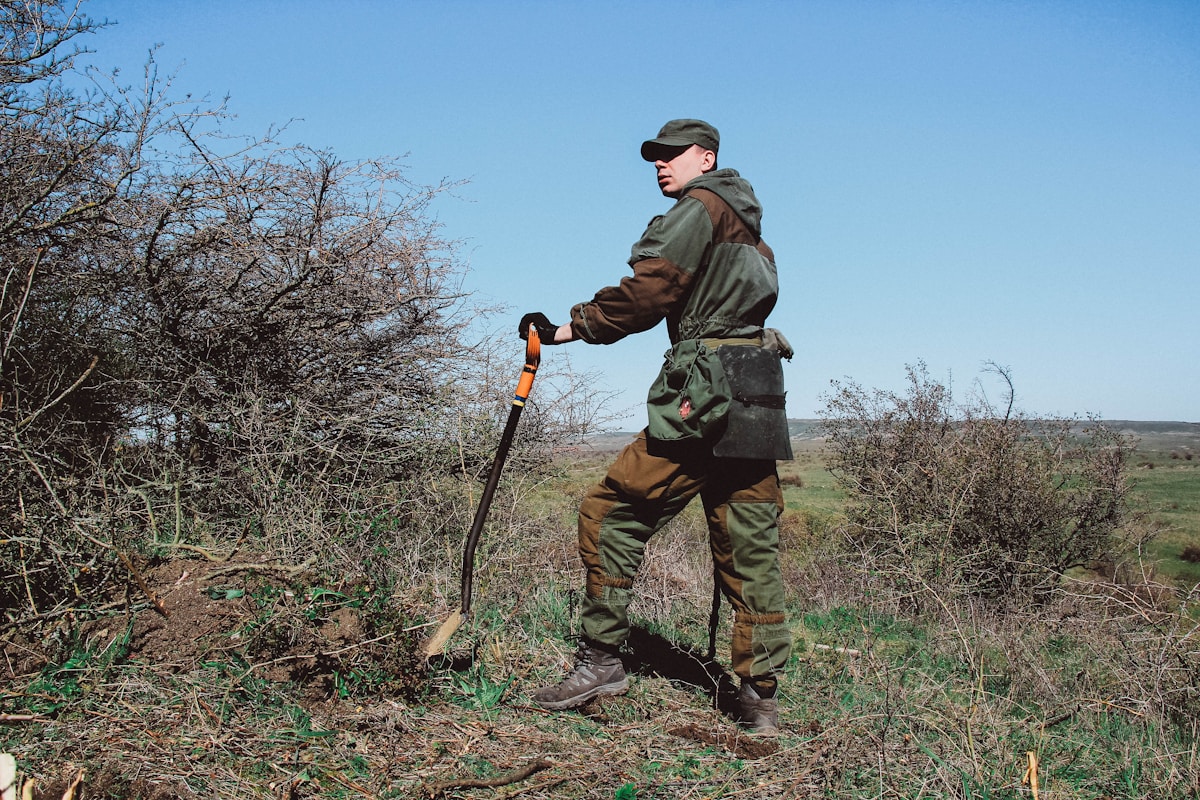 Homme en tenue de randonnée marchant dans la nature.
