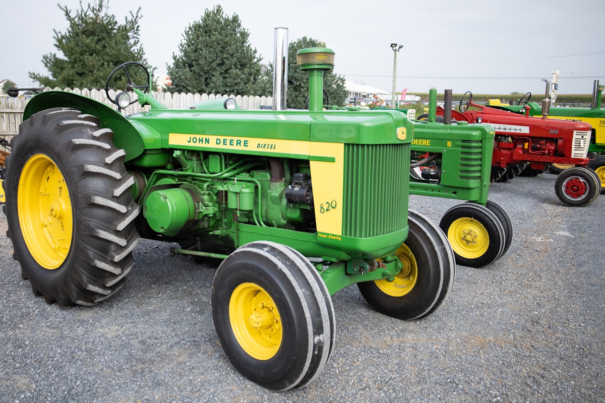 Tracteur agricole John Deere vert et jaune, avec de grands pneus et un moteur diesel.
