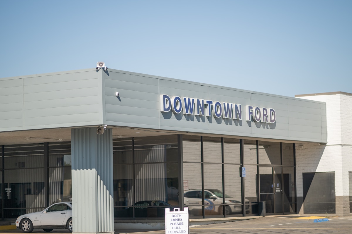 Bâtiment commercial avec enseigne "Downtown Ford" et voitures garées devant.
