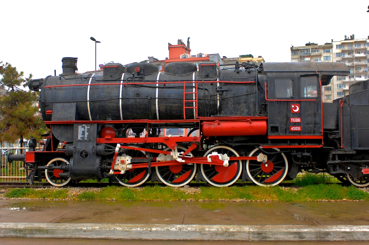 Locomotive à vapeur ancienne de couleur noire et rouge.